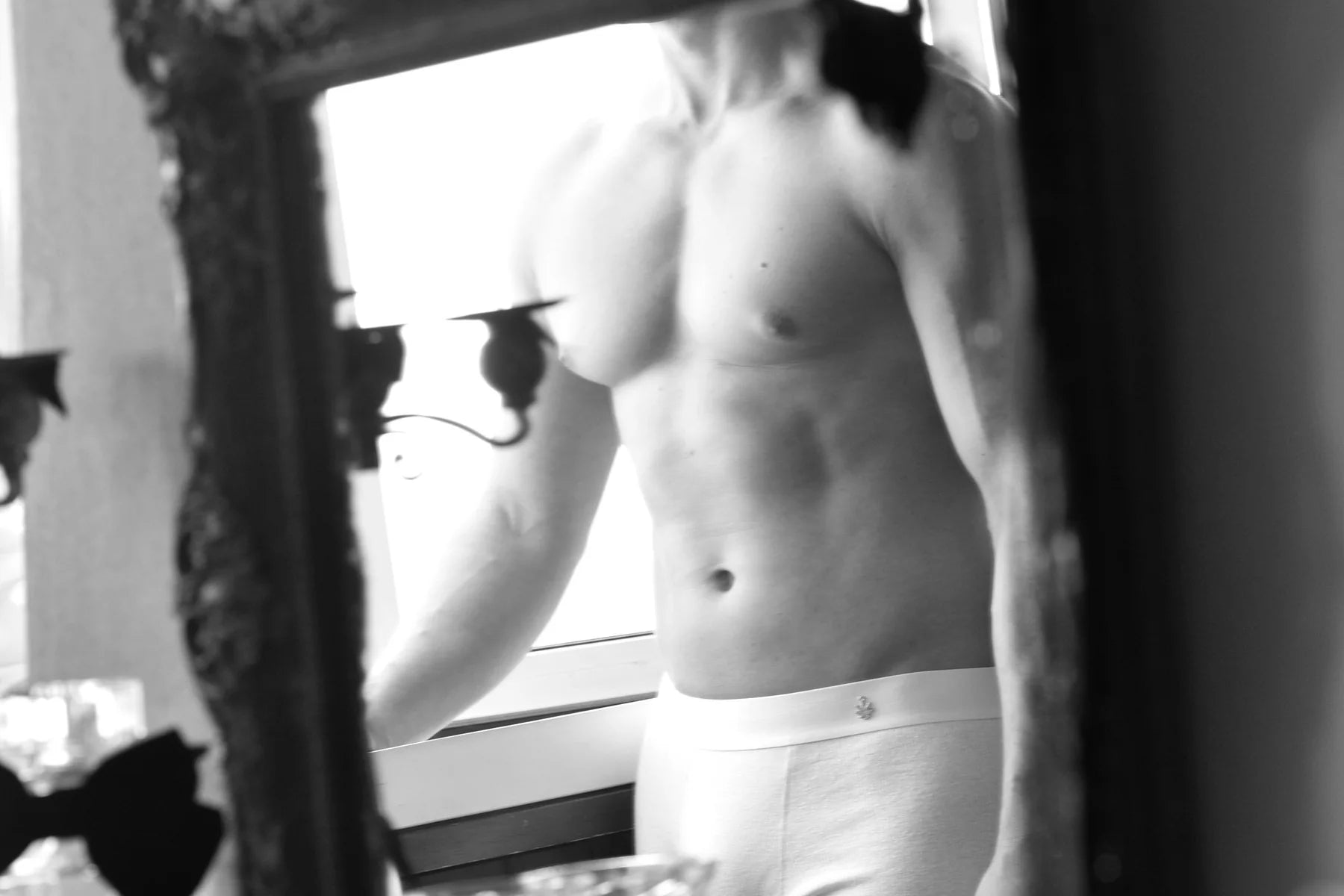 Men’s OLIVER KRAUS campaign portrait reflected in an ornate mirror.